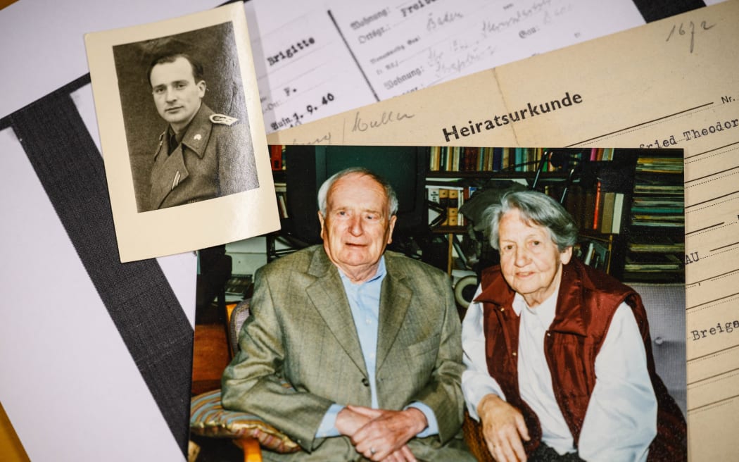 This photo taken on June 2, 2026 shows a picture (C) of German lecturer Felix Puelm’s grandparents Paul and Brigitte, a small picture (top L) of Paul in army uniform, their marriage certificate (R), and (bottom, white paper) a copy of a National Socialist German Workers’ party (NSDAP) membership card of his grandmother Brigitte that he found in an online database published by Die Zeit, a German national weekly newspaper, at Silpakorn University, in Nakhon Pathom province, west of Bangkok. (Photo by ANTHONY WALLACE / AFP)
