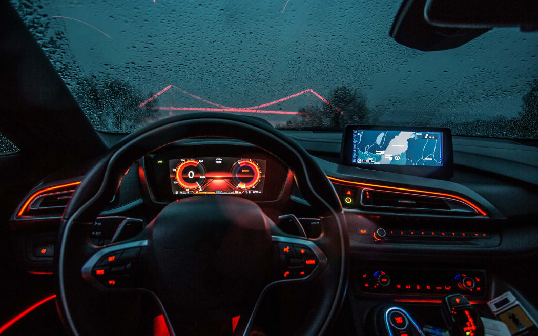 Direction wheel and navigation system of a car, red lights interior, electric vehicle. Generic.
