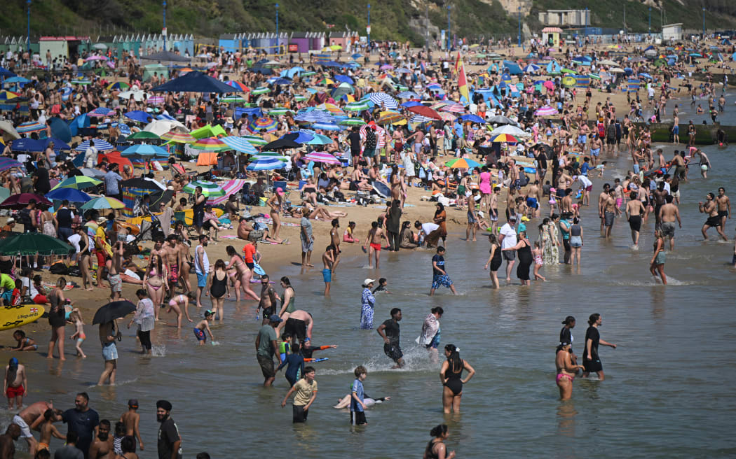 Sunbathers play in the sea and relax in the sunshine on Bournemouth beach on the south coast of England on May 26, 2026, as heatwave conditions spread to parts of southeast England and London. Britain registered on Tuesday its hottest-ever May temperature on record, with the mercury rising to 35C near the capital. (Photo by JUSTIN TALLIS / AFP)