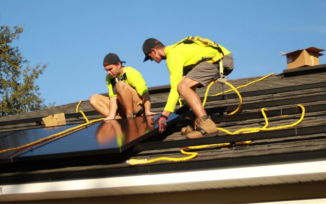 Workers installing rooftop solar.