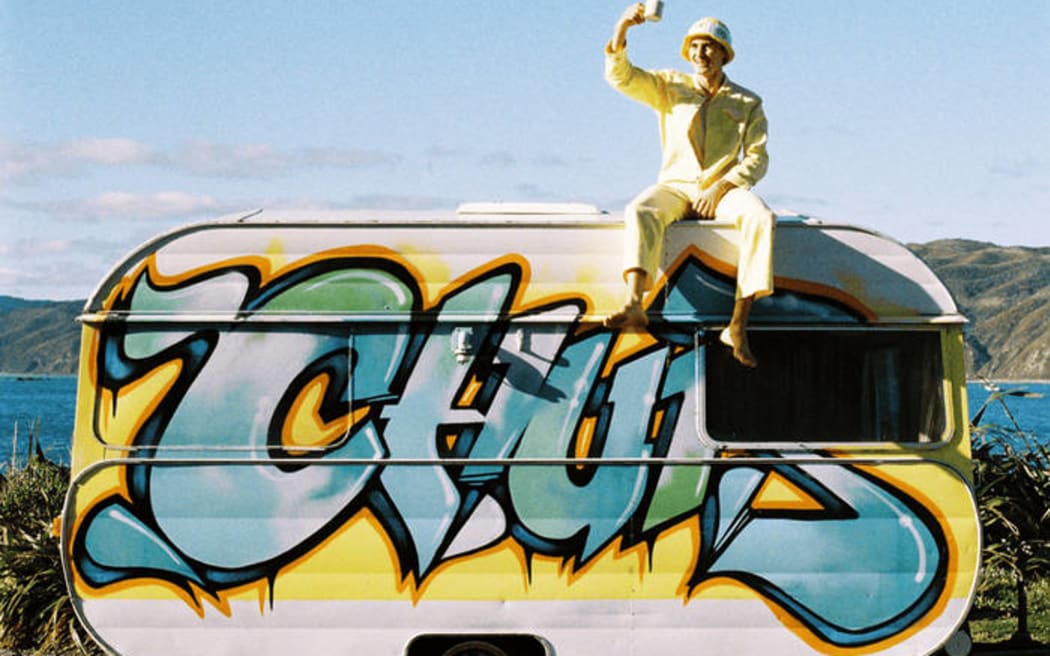 Cover image of the Casual Healing album, Driftwood. Artist sits on top of a caravan taking a selfie.