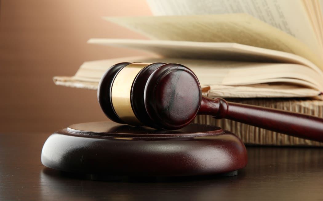 Wooden gavel and books on wooden table,on brown background
