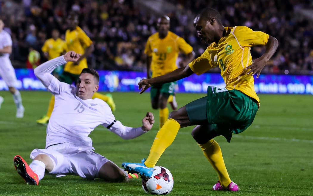 New Zealand's Storm Roux flies in to challenge South Africa's Themba Zwane in an international friendly in Auckland.
