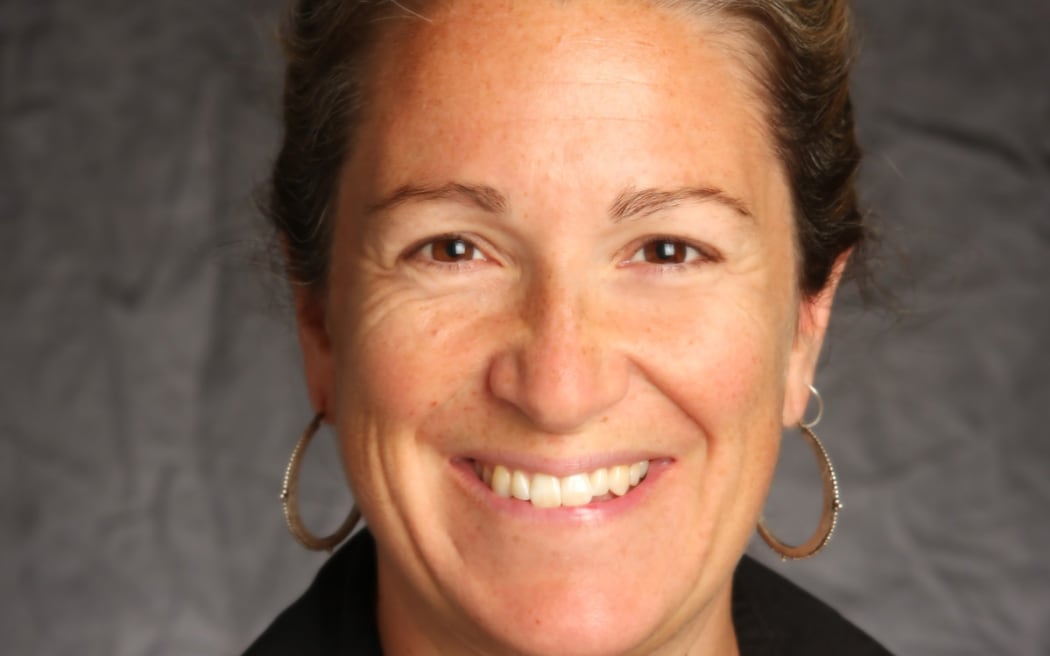 Picture shows a portrait of a woman smiling at the camera.