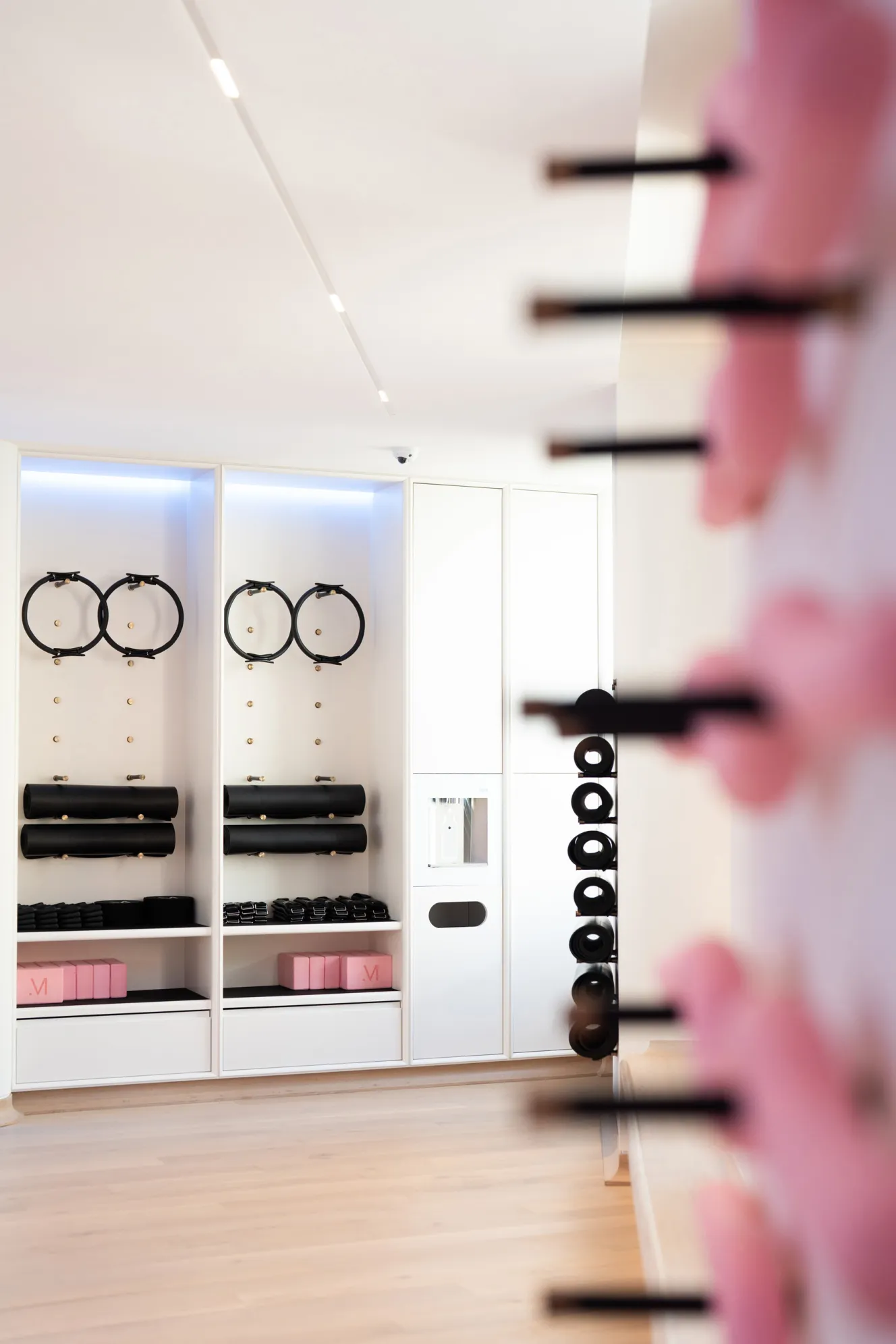 Storage units at The Method Club fitness studio, filled with exercise equipment like Pilates rings, mats, and blocks.