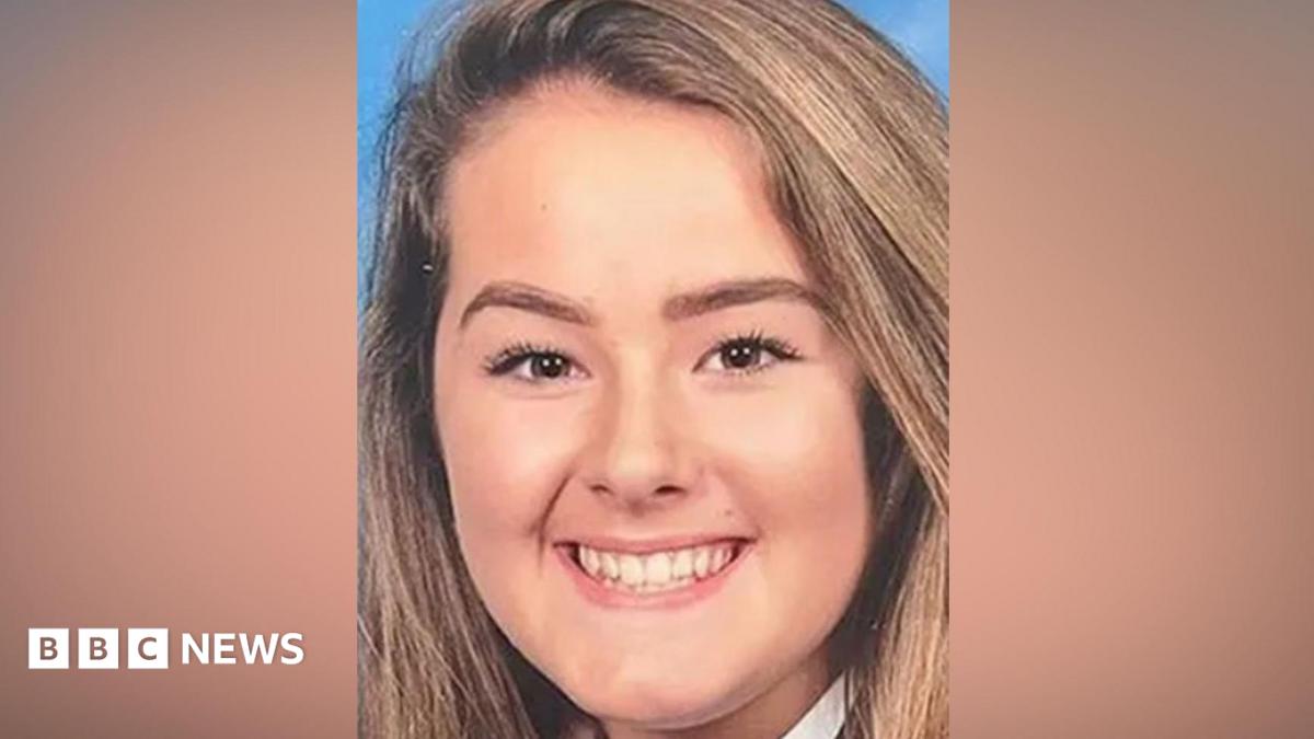 Emily Moore smiles at the camera in a school picture. She has brown eyes and long light brown hair.