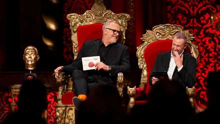 Greg Davies and Alex Horne share a laugh in their comically-sized throne chairs next to a golden statue of Davies’ head on the set of Taskmaster.