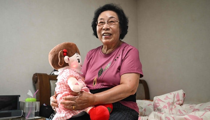 This picture taken on April 29, 2026, shows Bang Chun-ja, a South Korean elderly woman living alone, holding Hyodol, an AI-powered healthcare doll designed for elderly people, during an interview with AFP at her home in Yongin, South Korea. — AFP