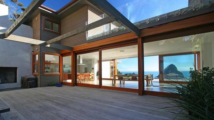 Jenene Crossan and Scottie Chapman are selling their luxury seven-bedroom beach escape at 27 Glenesk Road, above Piha’s Lion Rock, on Auckland's west coast. Photo / Supplied