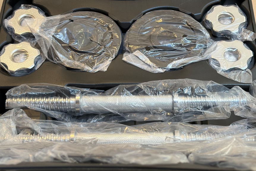 A carry case of dumbbells, with each piece individually wrapped in soft plastic.