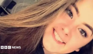 Emily Moore selfie. She is smiling at camera. She has long brown hair.