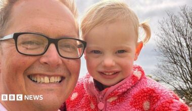Close-up of Dan Williams, who is wearing glasses, holding his granddaughter.