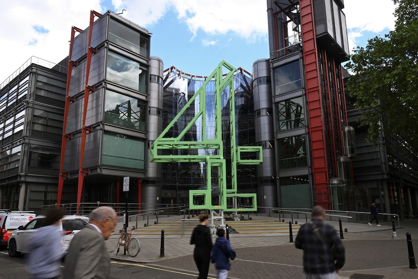 A building with people walking past outside. There is a large '4' sign outside the building.