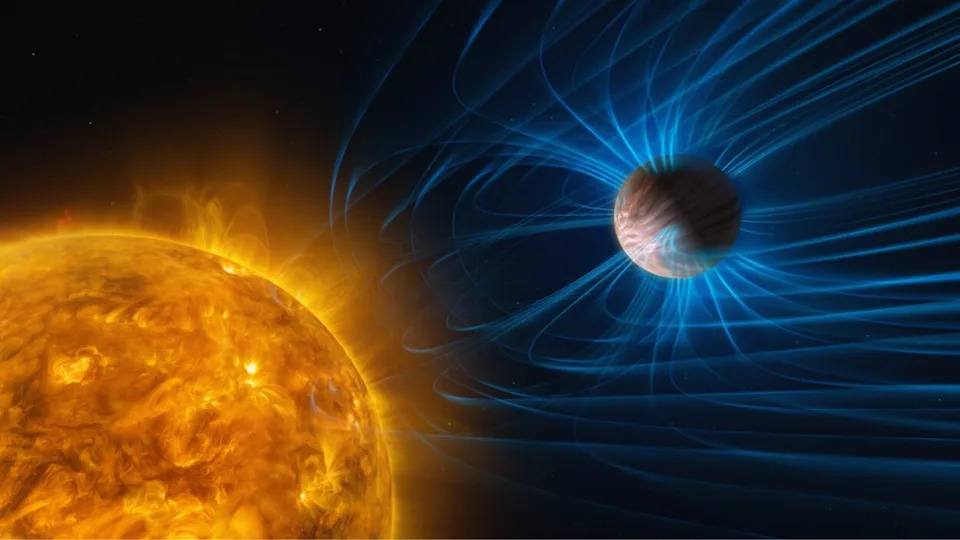 A star in the foreground with a planet toward the left with magnetic fields shown around it in blue.