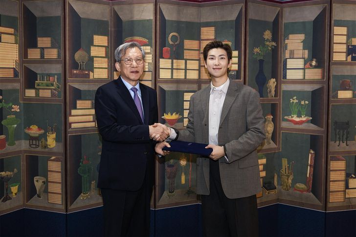 RM, right, the leader of K-pop supergroup BTS, shakes hands with You Hong-june, director of the National Museum of Korea, after being named global ambassador of the museum, in this photo provided by You's office, Saturday. Yonhap