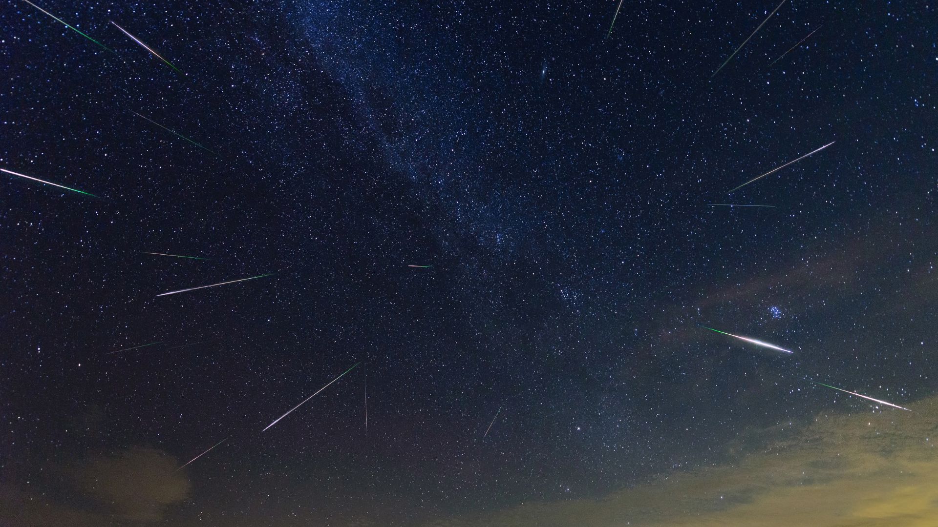Meteors a pictured streaking Earthward through a starry night sky.