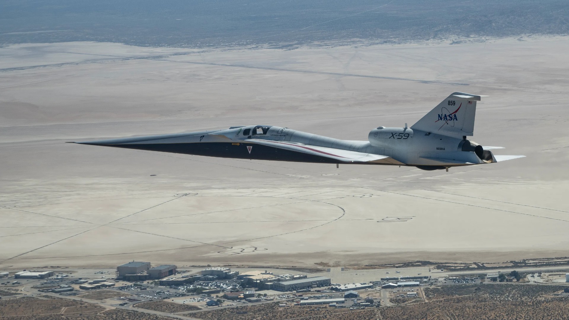 an elongated white jet files above the desert