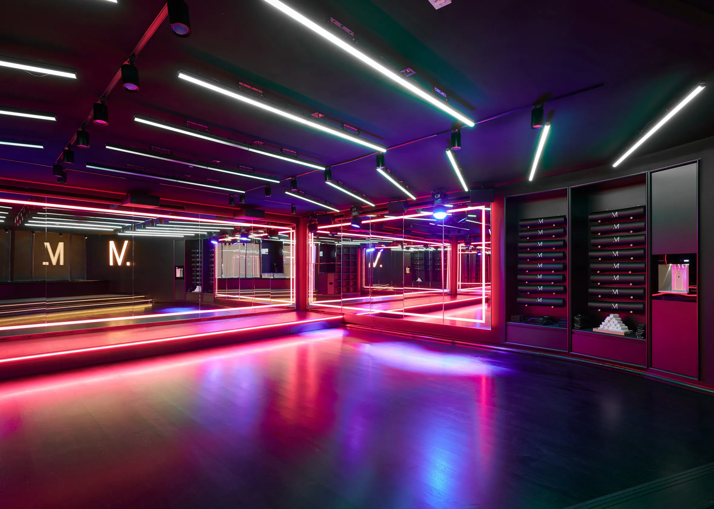 The Method Dance Studio interior with bright neon red and blue lighting illuminating the dance floor.