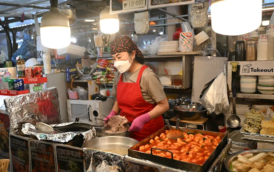 A vendor works at her food stall at Gwangjang Market in Seoul