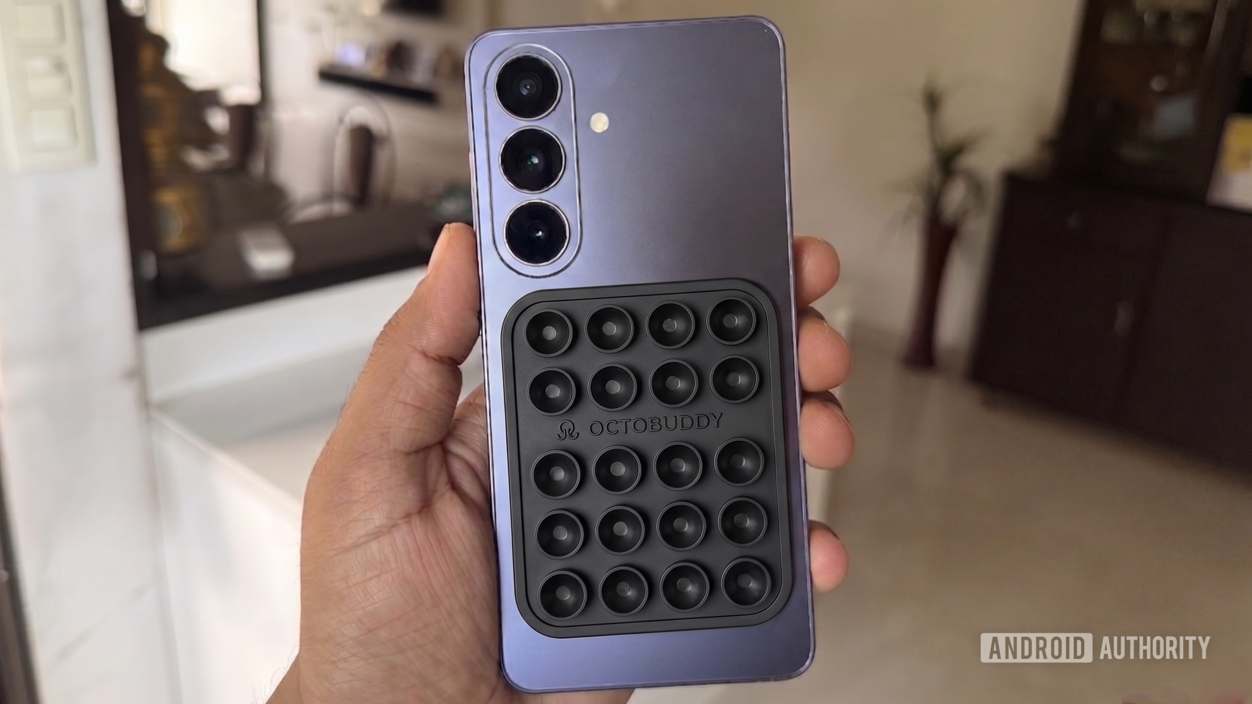 A phone in hand with silicone suction case on back