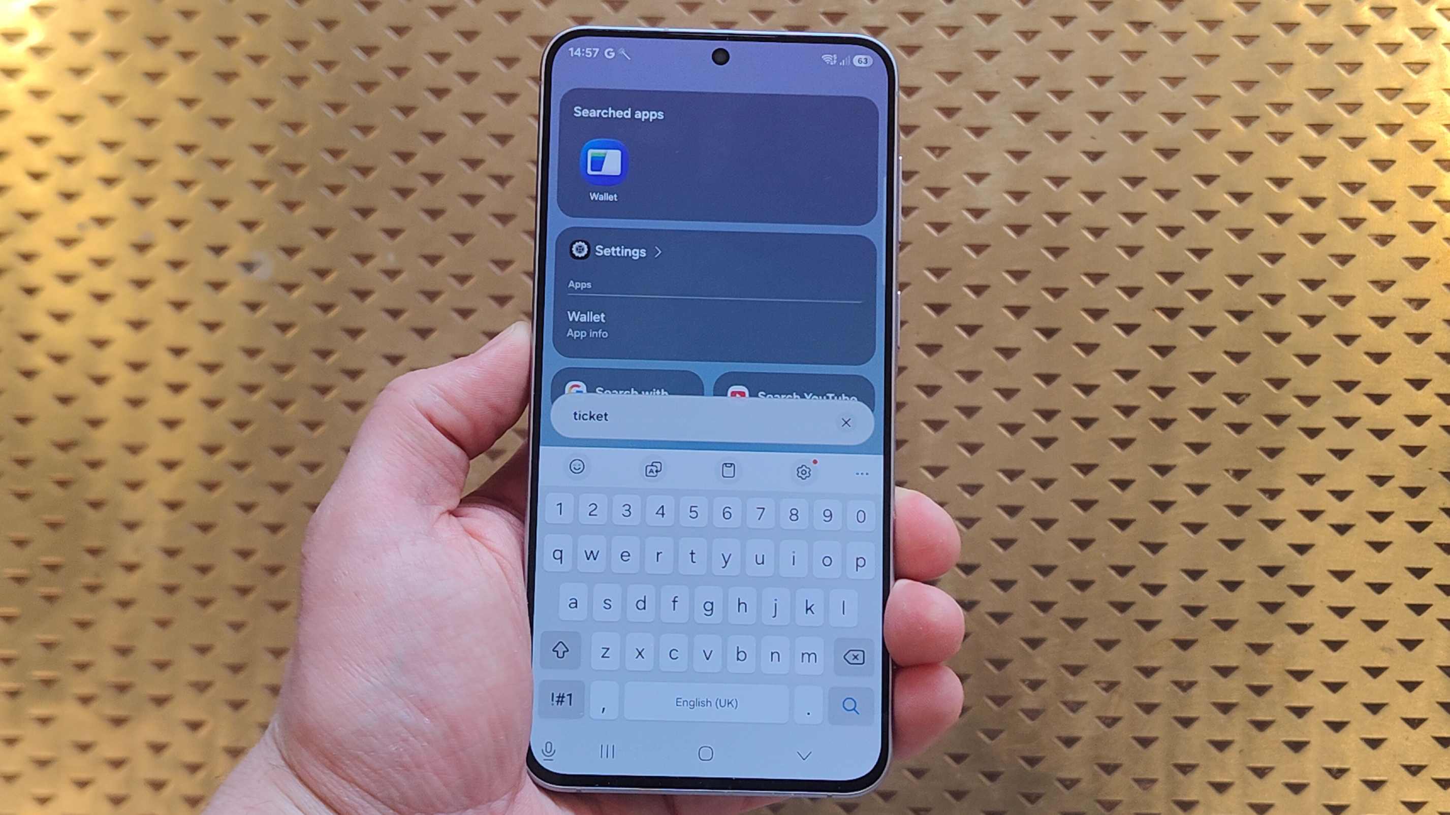The Samsung Galaxy A57 with Finder being used to search for a ticket.