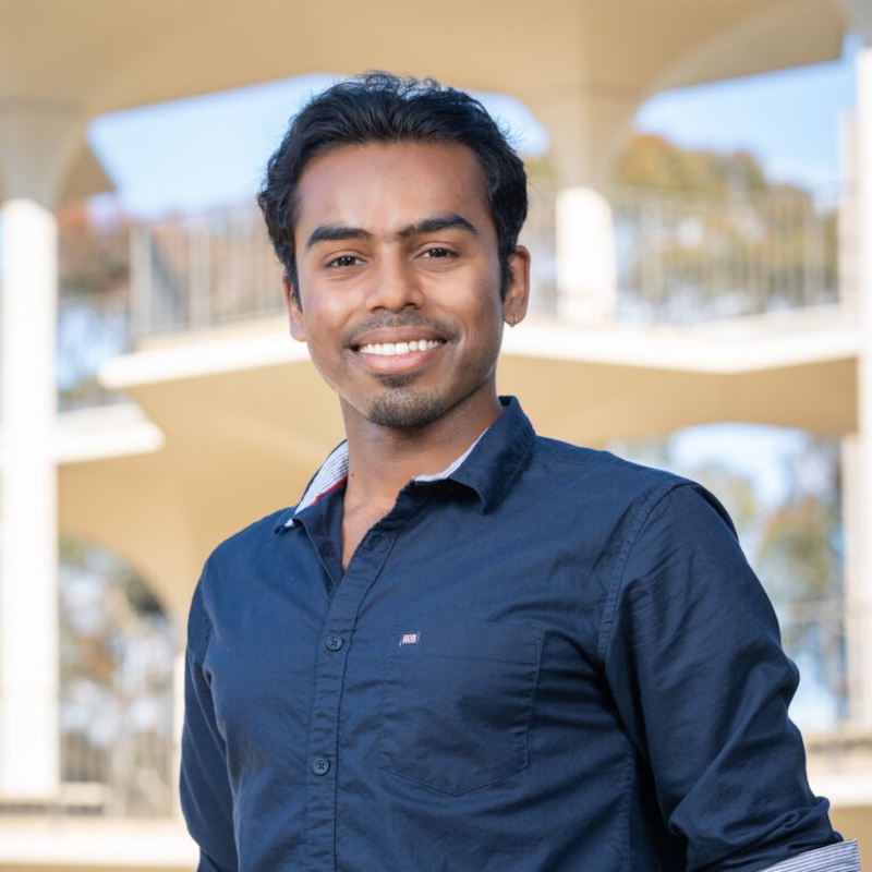 Smiling man wearing a dark blue shirt.