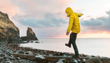 Man hanging in the balance over a log at seaside in Scotland