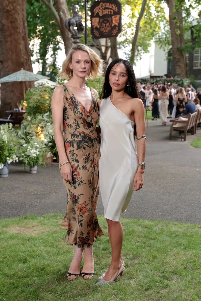 Carey Mulligan wears a Donna Karan floral dress with Zoë Kravitz in a silver silk dress at the Jessica McCormack Summer Solstice Party in London.