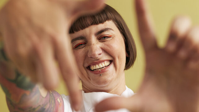 Portrait of cheerful woman making finger frame