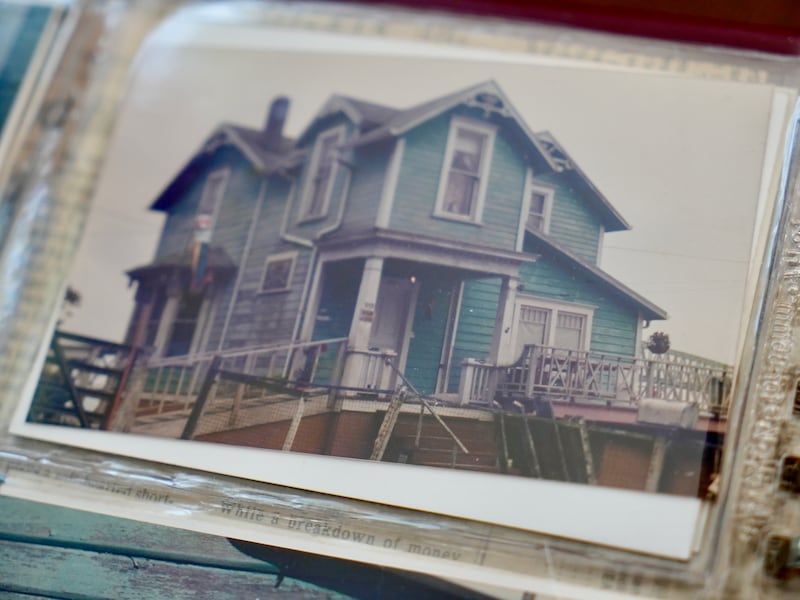 a photo in an album of a teal painted two story wood house
