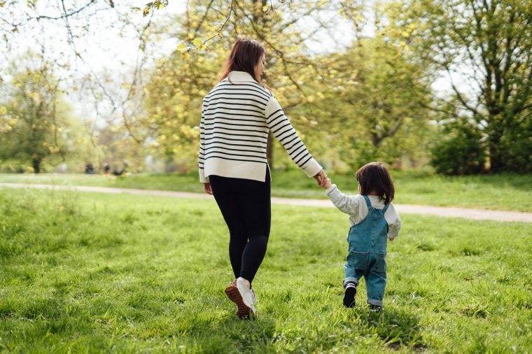 Young Asian mother enjoying family time with her toddler in nature - stock photo