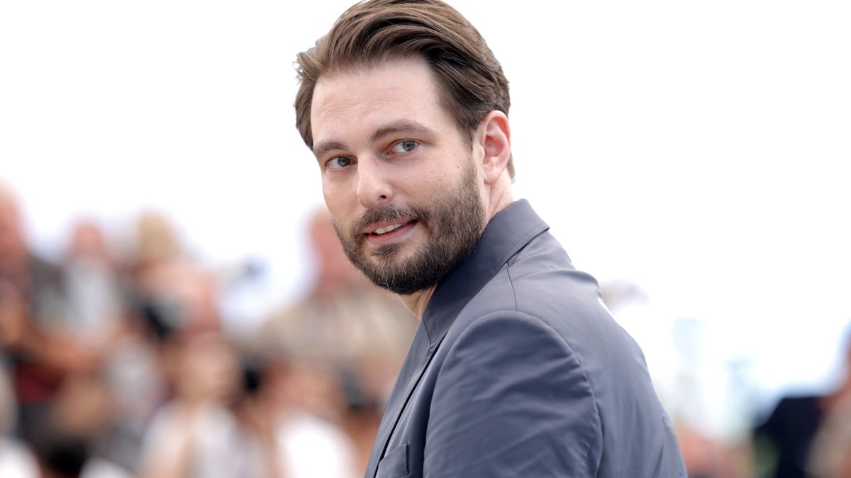 Sam Levinson standing at the Cannes film festival photocall.