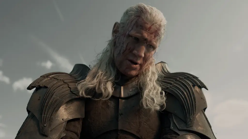Daemon Targaryen played by Matt Smith looks down at the camera covered in mudd on the battle field in HOUSE OF THE DRAGON Season 3. 
