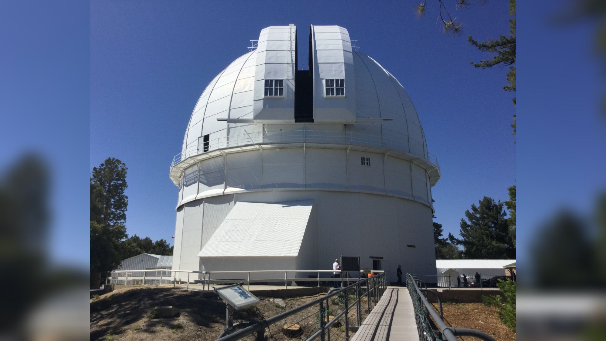 A photo of a white dome against a blue sky.