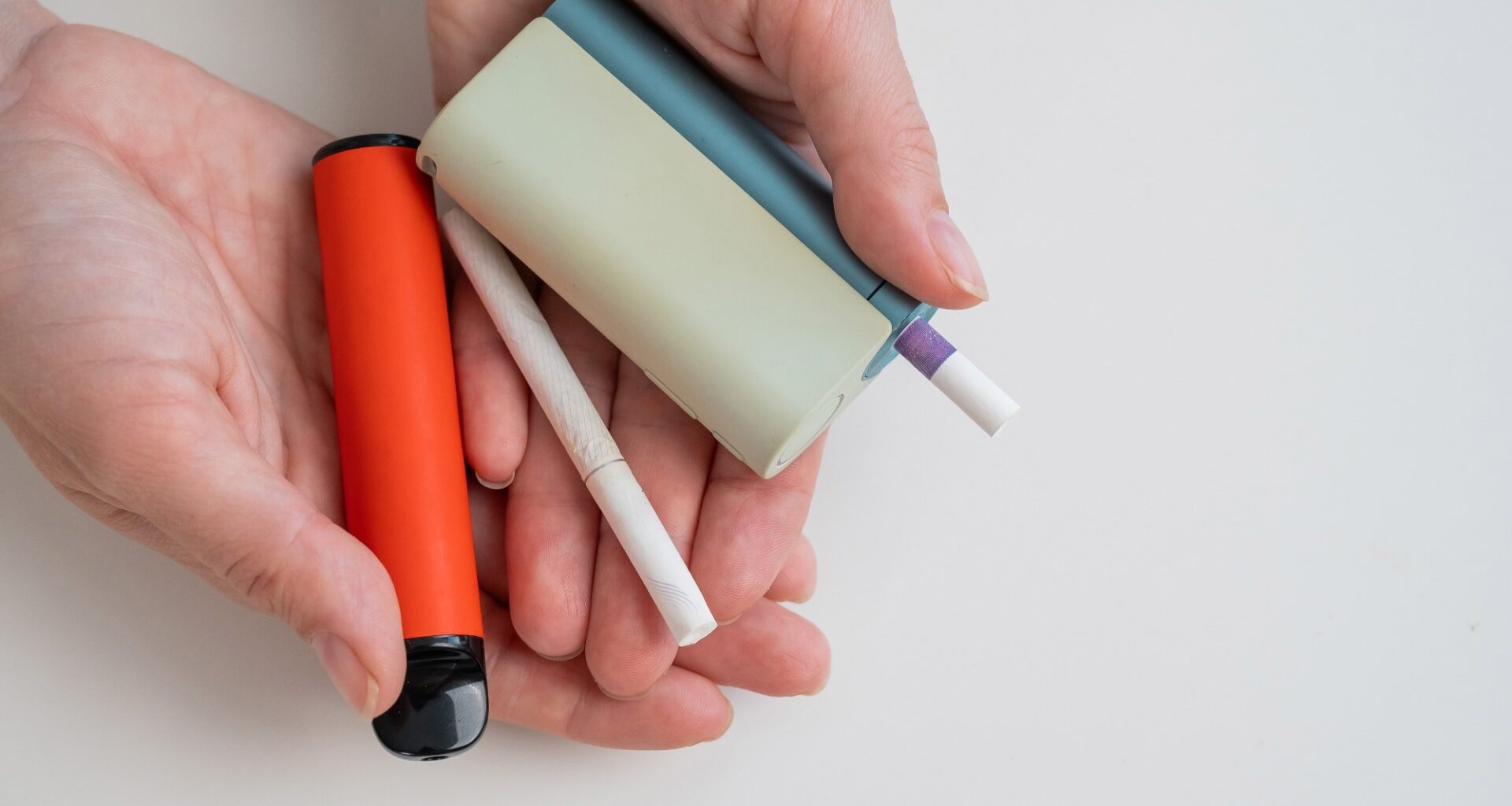 Woman holding regular, electronic cigarette and disposable vape on white background.