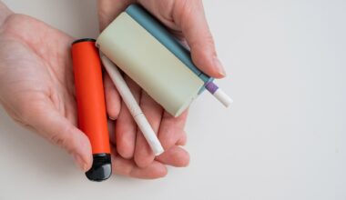 Woman holding regular, electronic cigarette and disposable vape on white background.