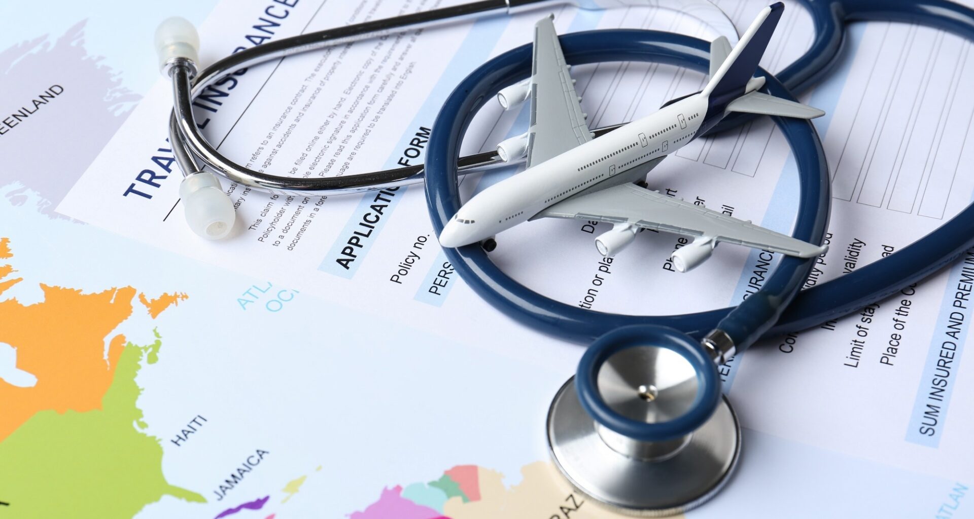 Medical tourism. Travel insurance application form, stethoscope and airplane model on world map, closeup