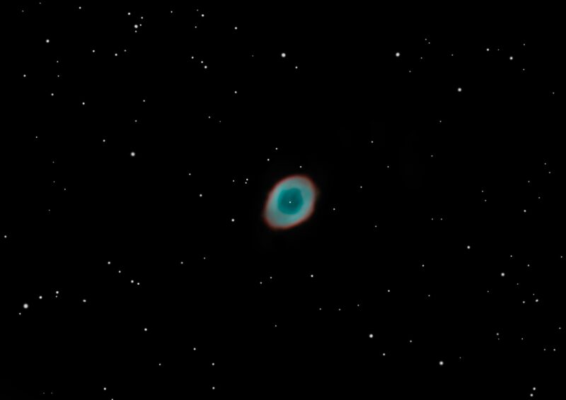 Small, ring-shaped cloud of gas in blue and orange, with sparse background stars.