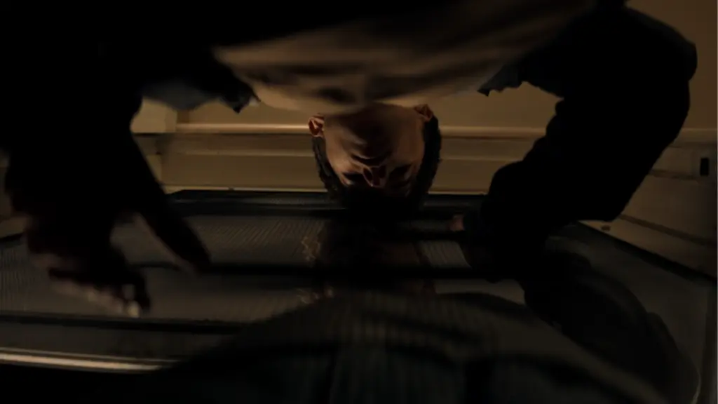 Joe Bird and Stacy Clausen try to embrace each other through a flimsy screen door in the queer Australian horror movie LEVITICUS. 