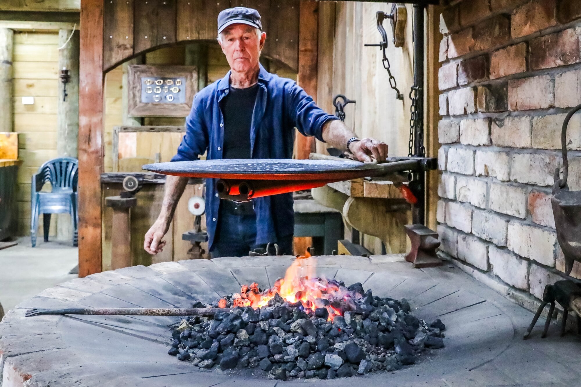 John Carmichael turns his blacksmith's fire into a barbecue.  Photo / Kelly O’Hara