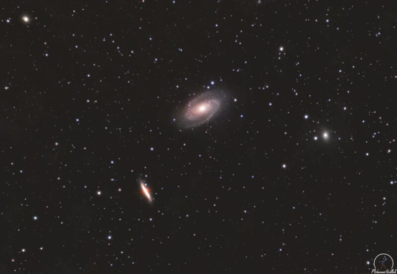 Two large, yellowish clouds, one irregular and another spiral, with numerous bright foreground stars.