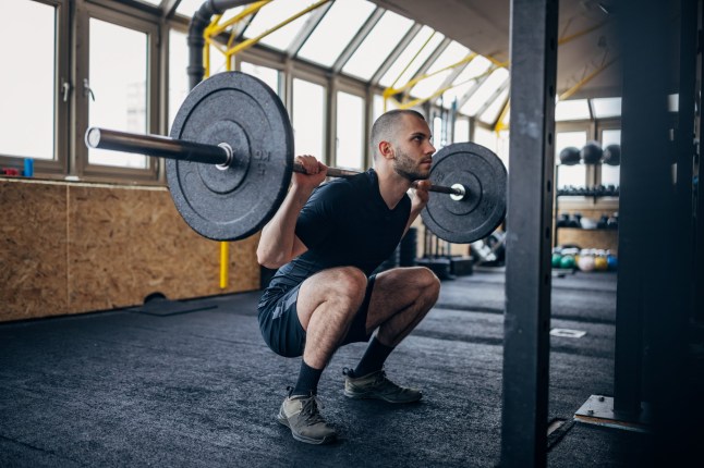 One young man training with weights in gym.