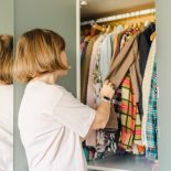 Young woman at home. sorting through and organizing her wardrobe