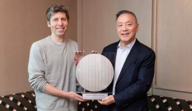 The CEOs of OpenAI and Broadcom stand flanking a circular semiconductor wafer.