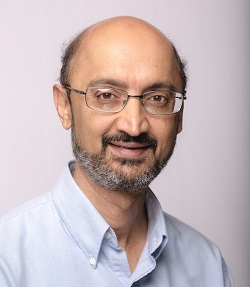 A head-and-shoulders image of a man wearing glasses