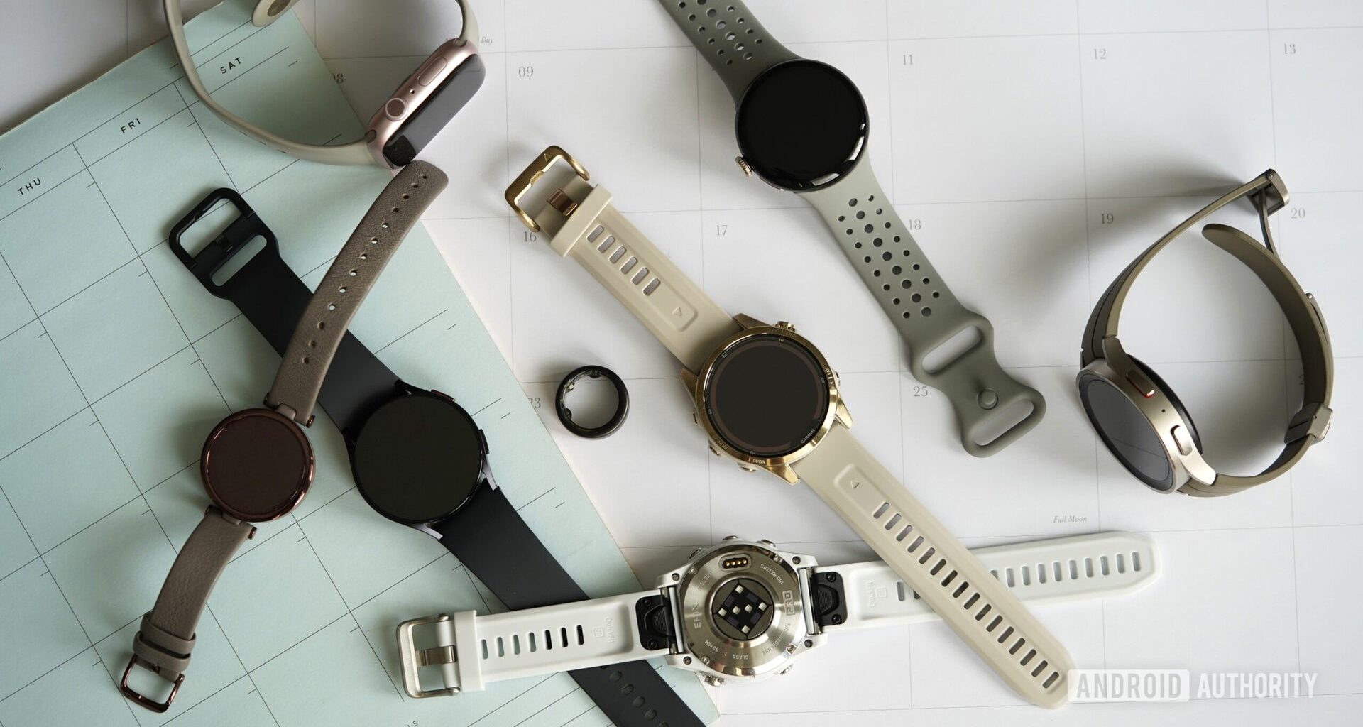 A variety of wearables rest on a collection of 2024 calendars.