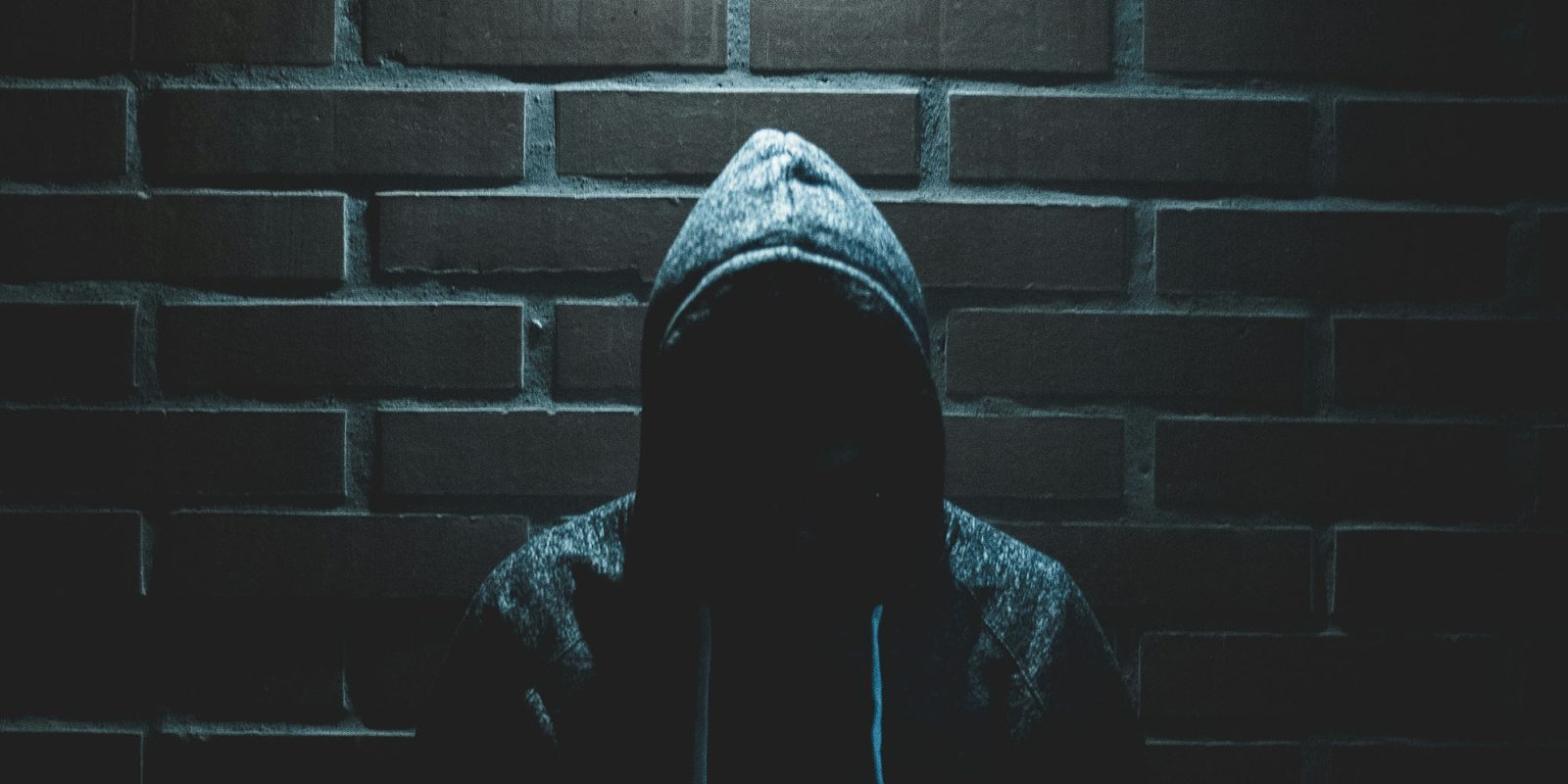 What to do if your iPhone is stolen – more detailed advice from Apple | Photo shows a face hidden by a hoodie on a dark night