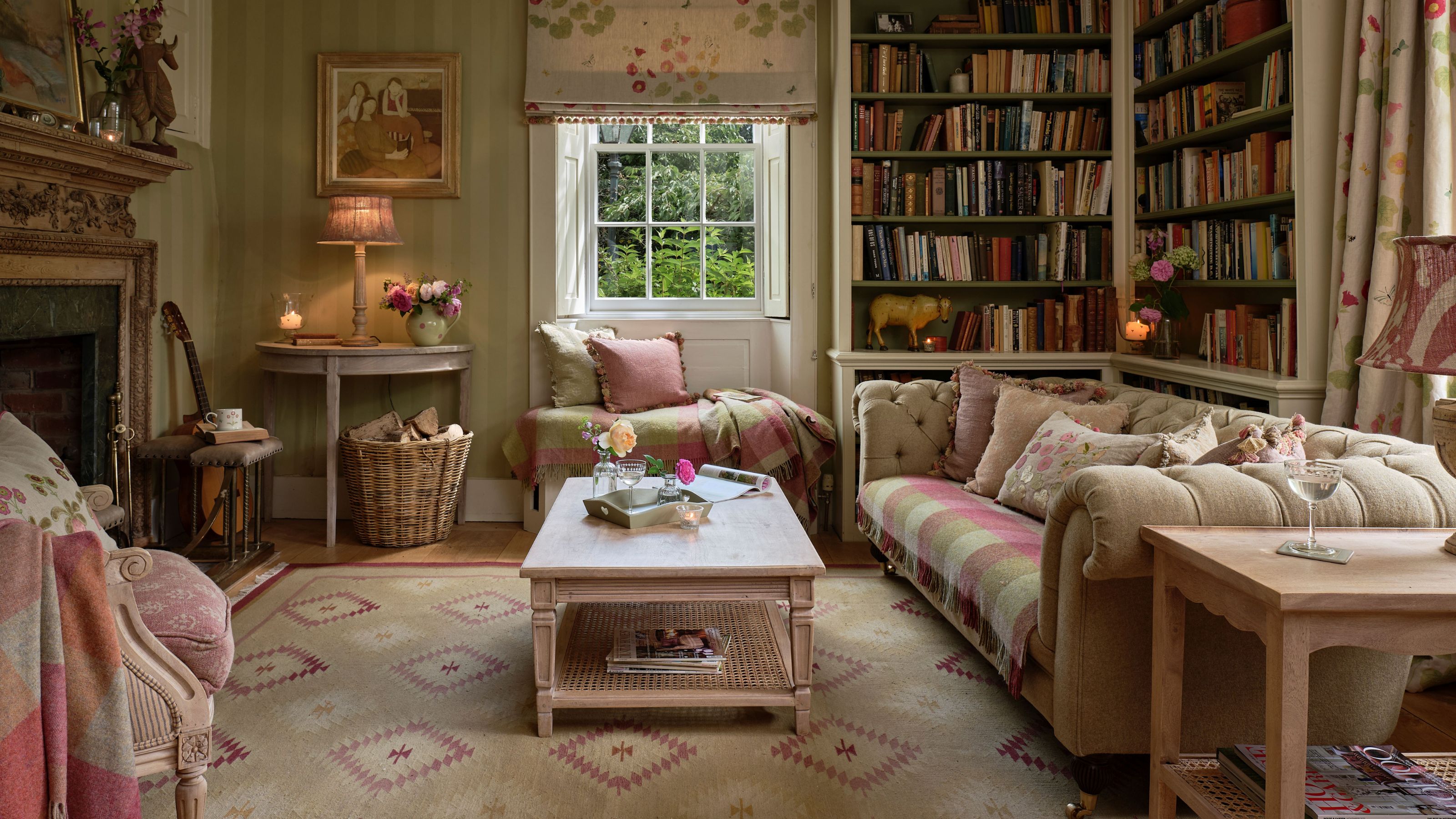 Cozy traditional living room with a large built-in bookcase, a tufted chesterfield sofa, and a classic ornate fireplace.