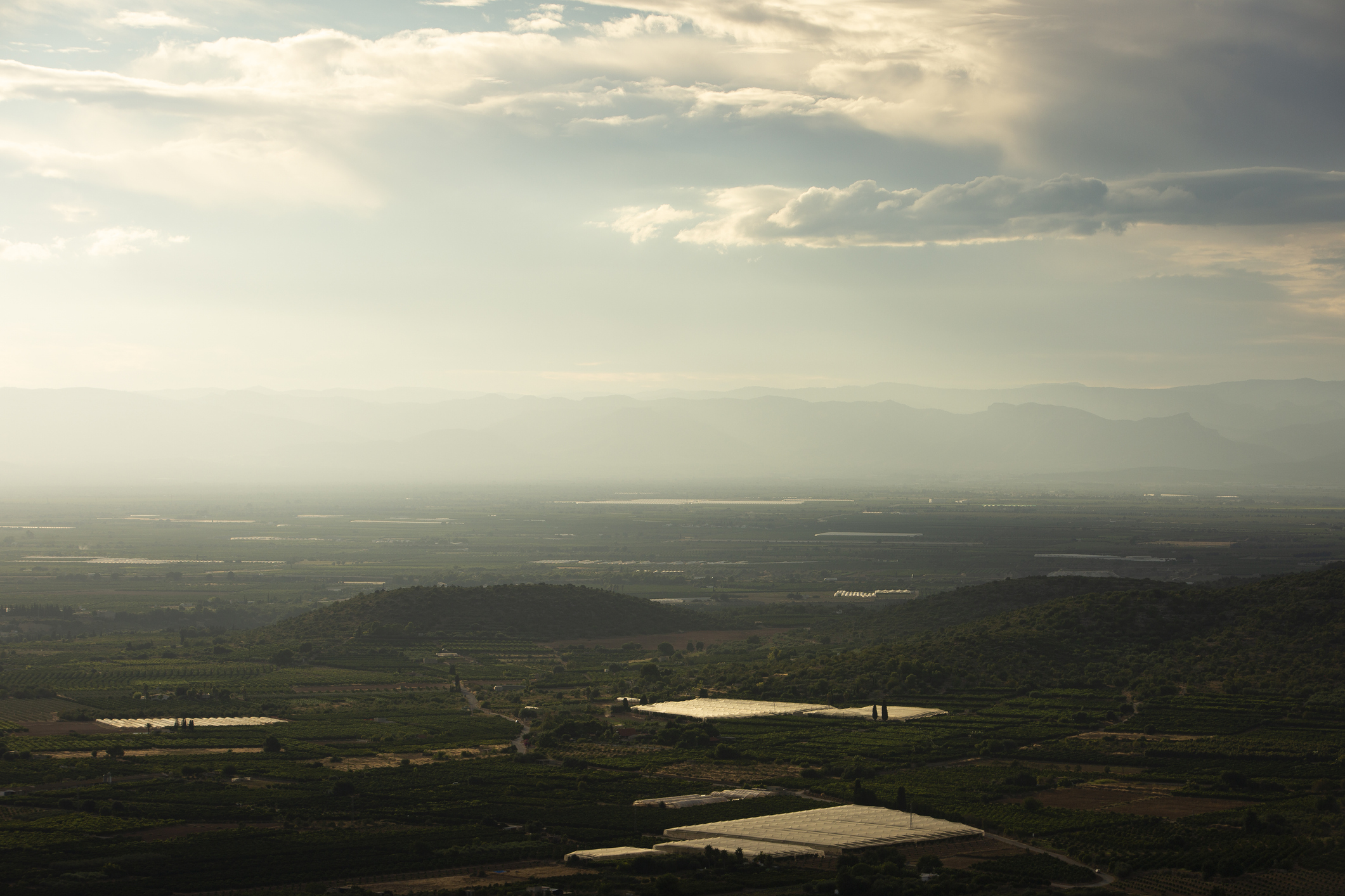 aerial view of a green landscape with a partly cloudy sky above.