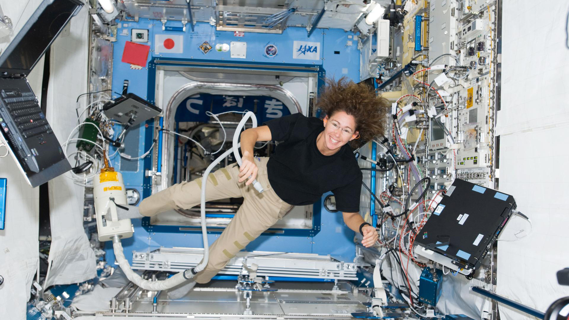 A woman with long curly hair floats in space.